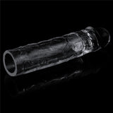 A realistic TPR sleeve resembling the Flawless Clear Penis Sleeve 2 with a textured surface and rounded closed end, showcased on a reflective black background. Crafted from skin-safe TPE, its contours and details stand out against the dark backdrop.