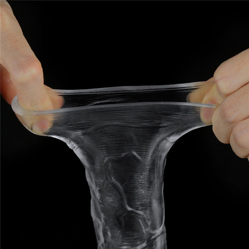 Hands stretch the Flawless Clear Penis Sleeve 2 against a black background, creating a translucent effect as thin strands form between fingers. The TPE material elongates into a smooth, glossy sheet when pressed, showcasing its flexible and skin-safe qualities.