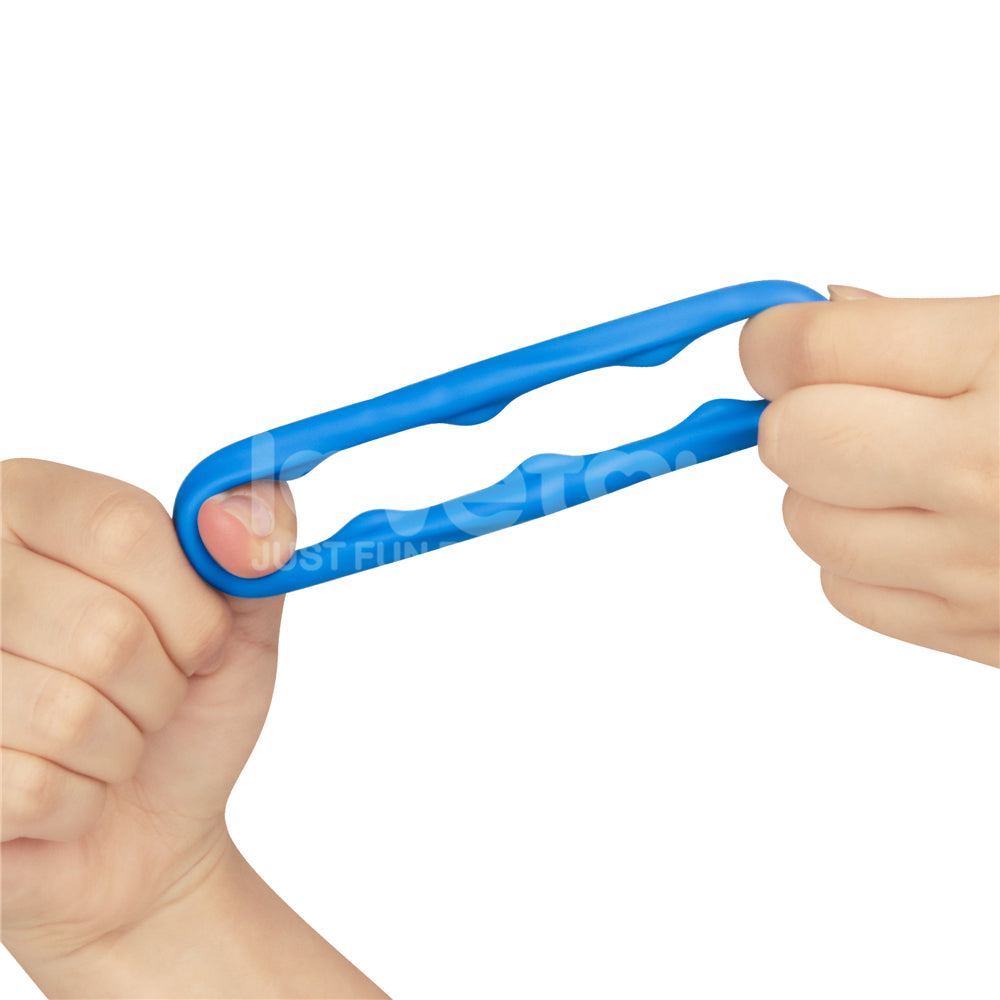 Two hands stretch a blue Pinnacle Pro Ridge Bump Stretcher, crafted from premium silicone with multiple holes for resistance training. Its oval design and finger placement indentations are highlighted against a plain white background, emphasizing the hands and exerciser.