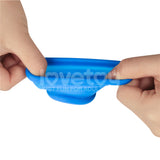 Hands pulling a blue Pinnacle Pro Tapered Squeeze ball stretcher, showcasing its smooth and flexible texture against a white background. The semi-transparent overlay reads lovetou, JUST FUN FOR ADULT.