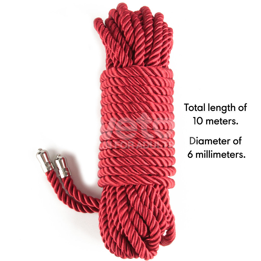 The Rebellion Reign Silky Bondage Rope in red features metal tips and is displayed flat against a white background. Its 10 meters long with a 6mm diameter, crafted from premium polyester for strength and elegance, perfect for adventurous use.