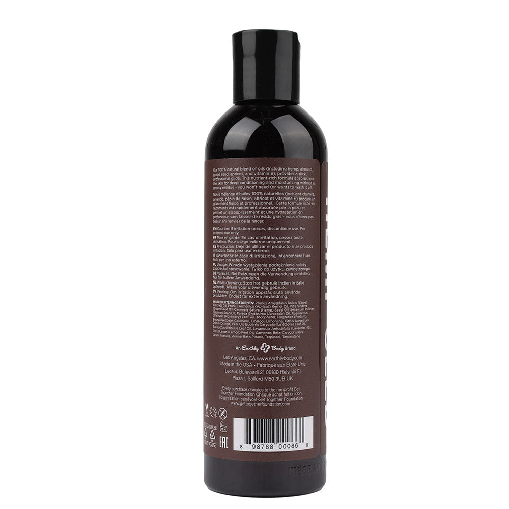 A 237 ml bottle of Hemp Seed Massage & Body Oil with lavender scent, featuring a black flip-top cap. The back label shows gray text with details about the all-natural product in multiple languages, and includes a barcode and recycling symbols on a brown background.