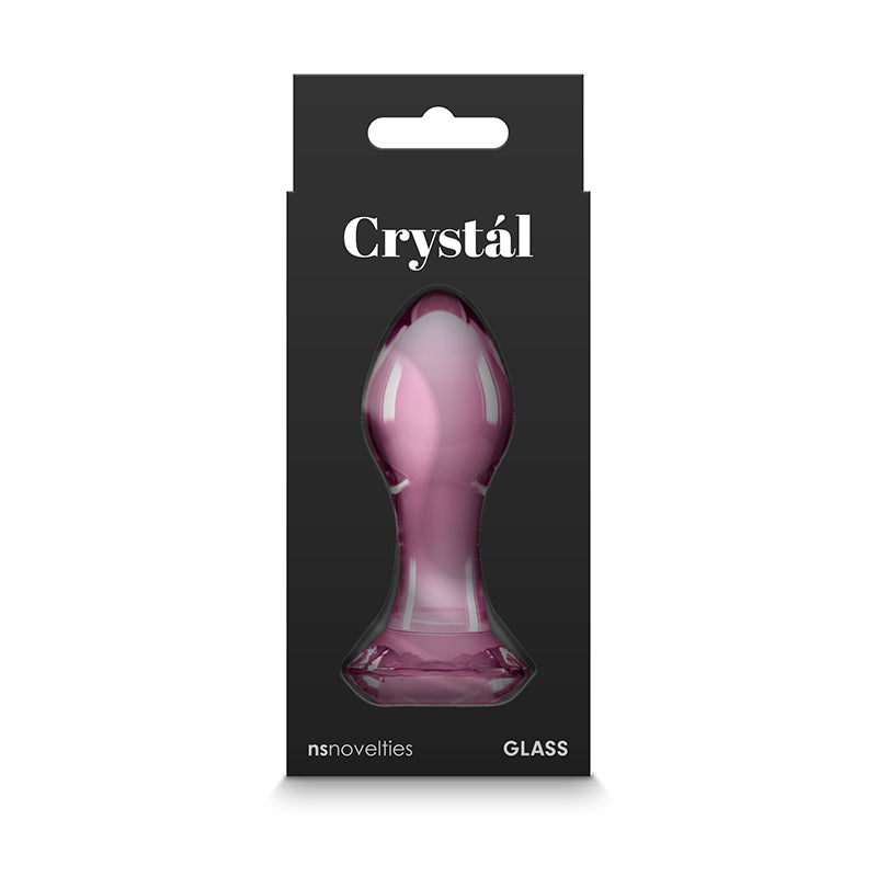 The Crystal Gem - Pink sex toy features elegant black packaging showcasing a translucent pink plug in hygienic borosilicate glass. With its teardrop shape and flared base, it promises a refined experience. nsnovelties and GLASS are prominently printed at the bottom in white text.