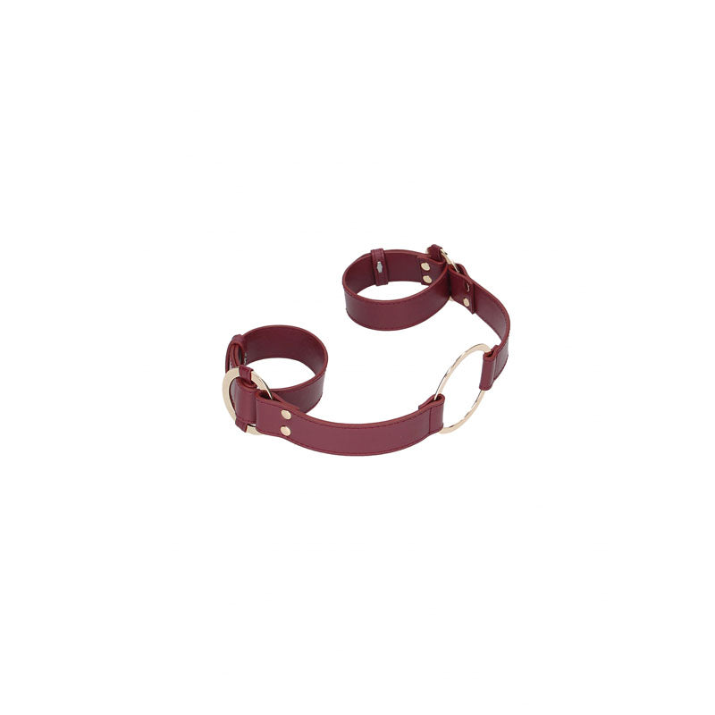 Part of the exquisite BDSM kit, the OUCH! Halo - Handcuff With Connector features a burgundy collar and cuffs linked by gold hardware, with cuffs offering silver rivets and buckles for adjustable sizing, ensuring secure fastening and a smooth finish against a plain white background.