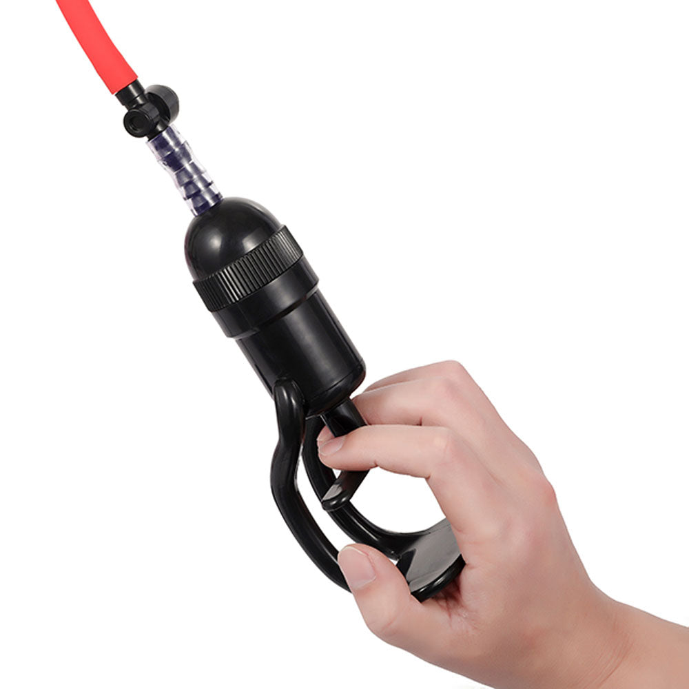 A hand holds the LuvPump Vagina Enhancement System, featuring a black medical-grade polycarbonate siphon pump with a ribbed grip and looped handle. The transparent connector secures the red hose for enhanced functionality in this body-enhancing device.