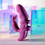 The Playboy Pleasure LEND A HAND - Purple USB Rechargeable Finger Vibrator, crafted from body-safe silicone with dual motors and unique dual arms for G-spot exploration, stands upright amidst colorful, translucent geometric shapes in blues, purples, and greens for a modern aesthetic.