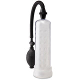 The Pump Worx Silicone Power Pump is a clear cylindrical penis pump featuring a textured inner sleeve, flexible black hose, and squeeze bulb for erection enhancement. Its white base emphasizes the dotted chamber design against a pristine white backdrop.