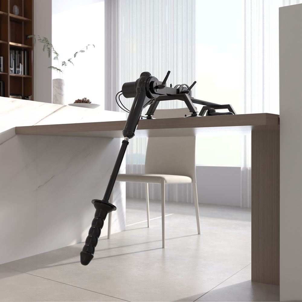 An FFS Body Dock Sex Machine, sleekly designed, sits on a marble or white countertop with its advanced thrust capability visible in the robotic arm reaching down. Nearby, a modern white chair stands in sunlight streaming through sheer curtains, highlighting the minimalist interior with shelving and decorative plants.