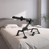 An FFS Body Dock Sex Machine with a flexible arm and handle rests on a neatly made bed adorned with a neutral-colored quilt. Its stable suction-cup base ensures secure placement. The softly lit, minimalist room, featuring a small plant in the background, promises elegance and discretion.