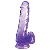 The King Cock Clear 6 Cock with Balls in purple has a realistic design, including a head, textured veins, and enlarged balls. It stands upright and features a suction cup base for stability.