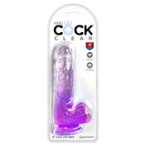 The clear packaging highlights the King Cock Clear 6 Cock with Balls - Purple, a realistic translucent purple 15.2 cm dildo with lifelike design and strap-on compatibility. It features a strong suction cup base for upright use, all enclosed in a neat plastic package.