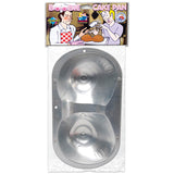 The Boobie Cake Pan - Novelty Cake Pan is a metal pan shaped like two breasts, ideal for baking cheeky snacks. The cover displays a man in an apron serving cake at a bachelor party, with a smiling woman. The packaging reads Boobie Cake Pan.