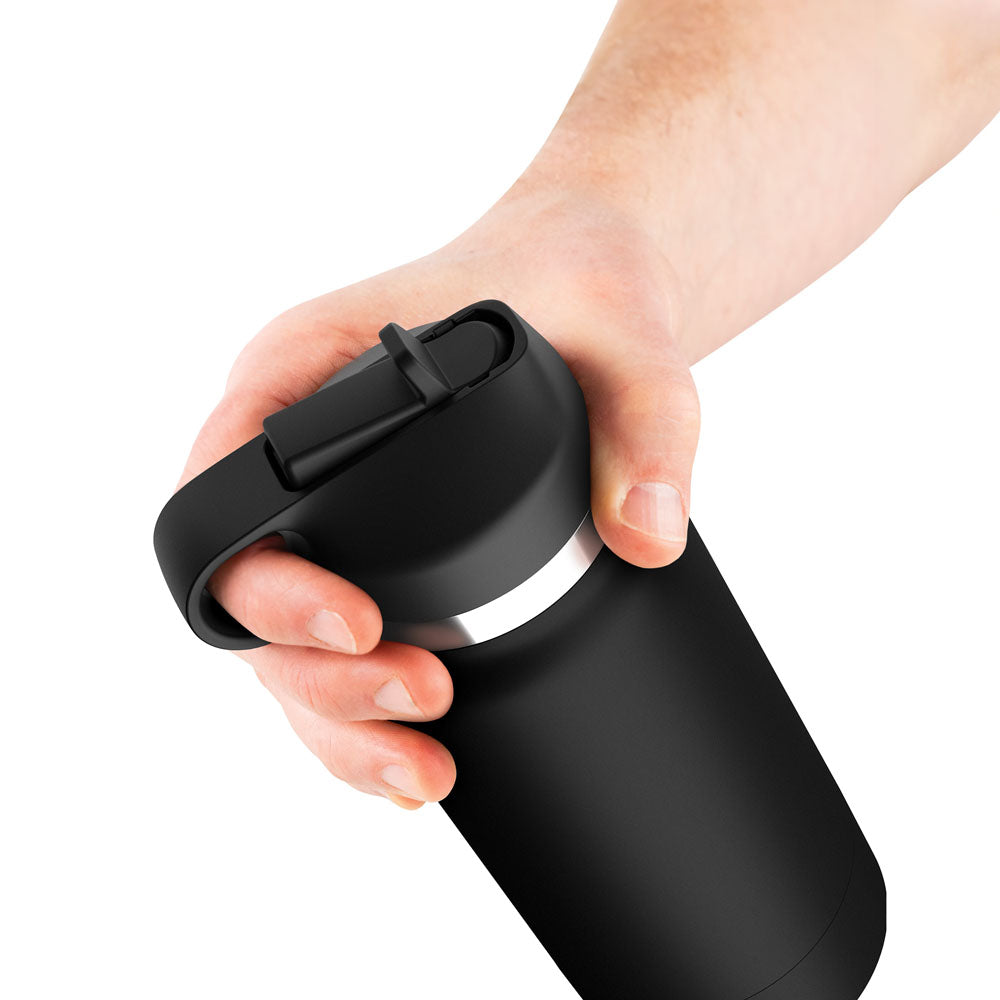 A hand holds the PDX Plus Fap Flask, Thrill Seeker edition, featuring a frosted discreet stroker. With a sleek black matte finish and a partially open flip-top lid, its gripped by its sturdy handle against a plain white background—perfect for thrill-seekers on the go.