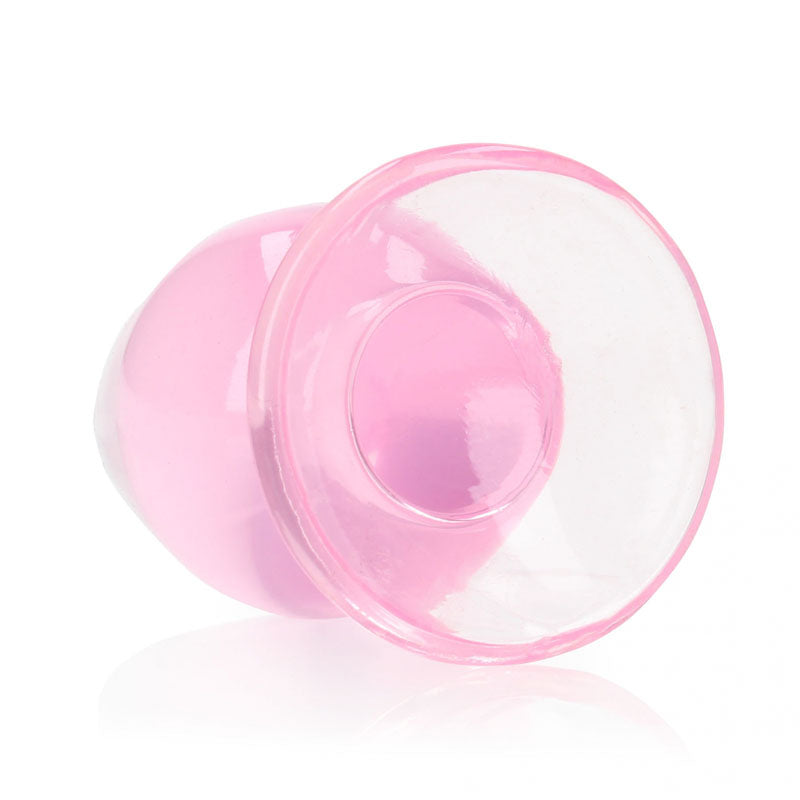 A round, pink REALROCK 9 cm Anal Plug features a silicone suction cup with a crystal-clear rim. Its vibrant color and distinctive shape stand out against a plain white background, ideal for applications needing a seal or vacuum.