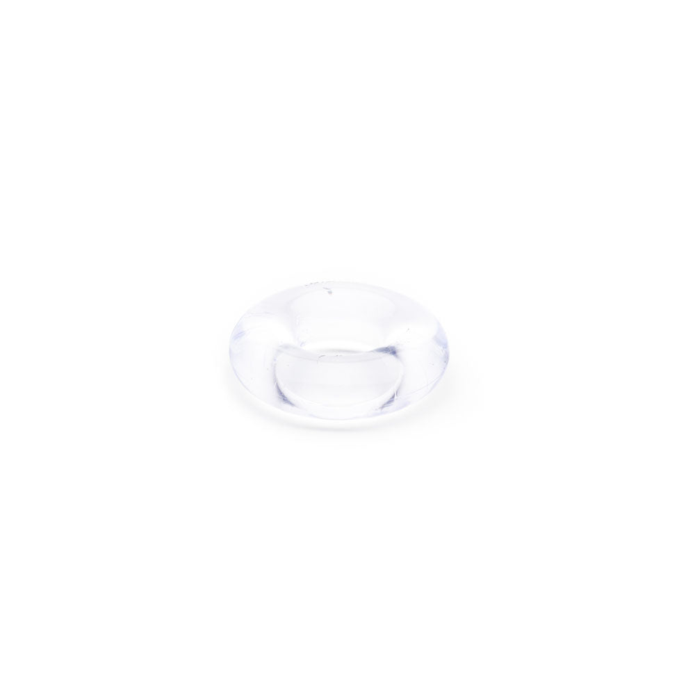 A small, clear glass bead with a donut-like shape sits on a plain white background. Crafted from thermo plastic rubber, its smooth surface allows light to refract, creating subtle reflections similar to the Sport Fucker Rubber Cockring - Clear Cock Ring.