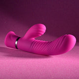 Set against a sparkly magenta backdrop, the Selopa NEXT WAVE - Pink 16.4 cm USB Rechargeable Dual Vibrator features powerful motors, ribbed texture, a curved end, and a smaller rounded extension. A metallic band accents the base for a sleek, modern look.