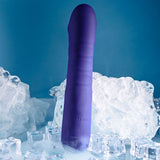 The Selopa AMBITION is a 17 cm purple, USB rechargeable thrusting vibrator that stands upright among ice cubes on a reflective surface. Its smooth design shows a subtle brand imprint against a cool blue backdrop, enhancing the icy theme.