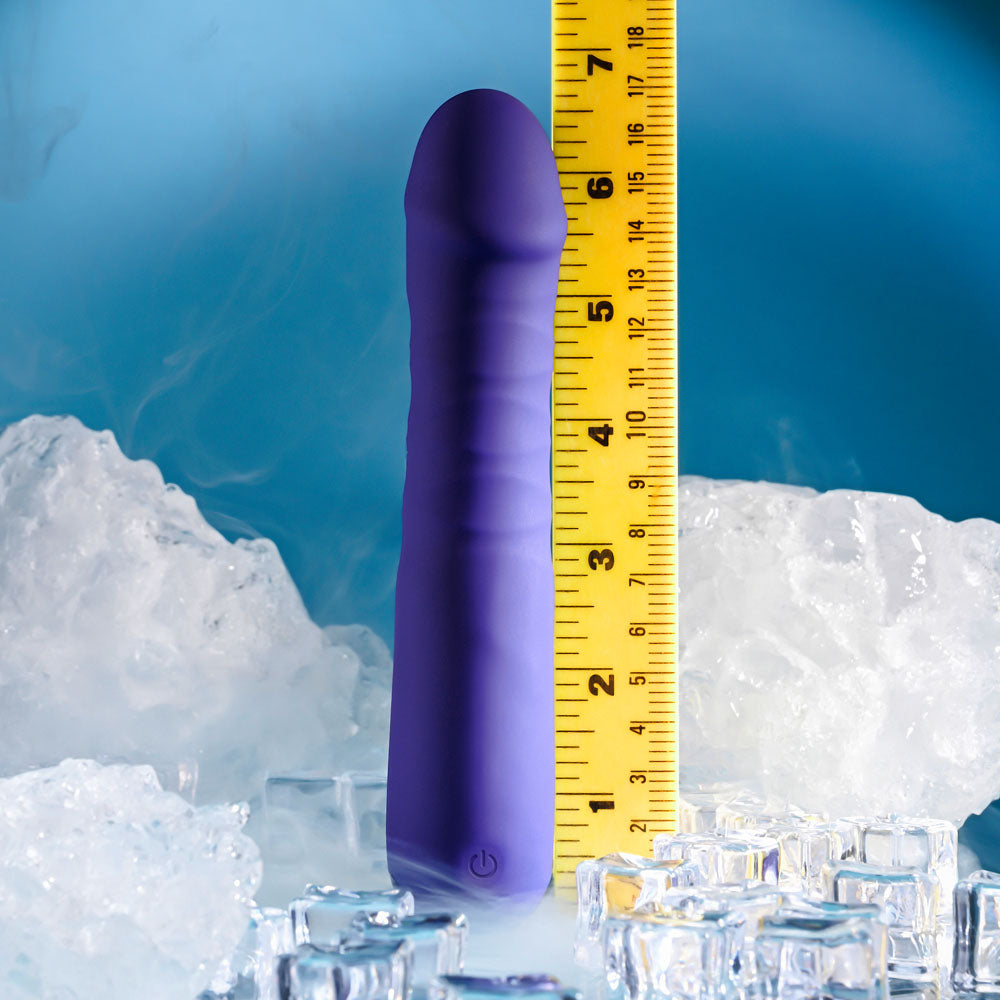 A purple Selopa AMBITION, a USB rechargeable 17 cm thrusting vibrator, stands vertically against a light blue background. Next to it is a yellow measuring tape showing its height of about 7 inches. Ice cubes and fog create a cool atmosphere.