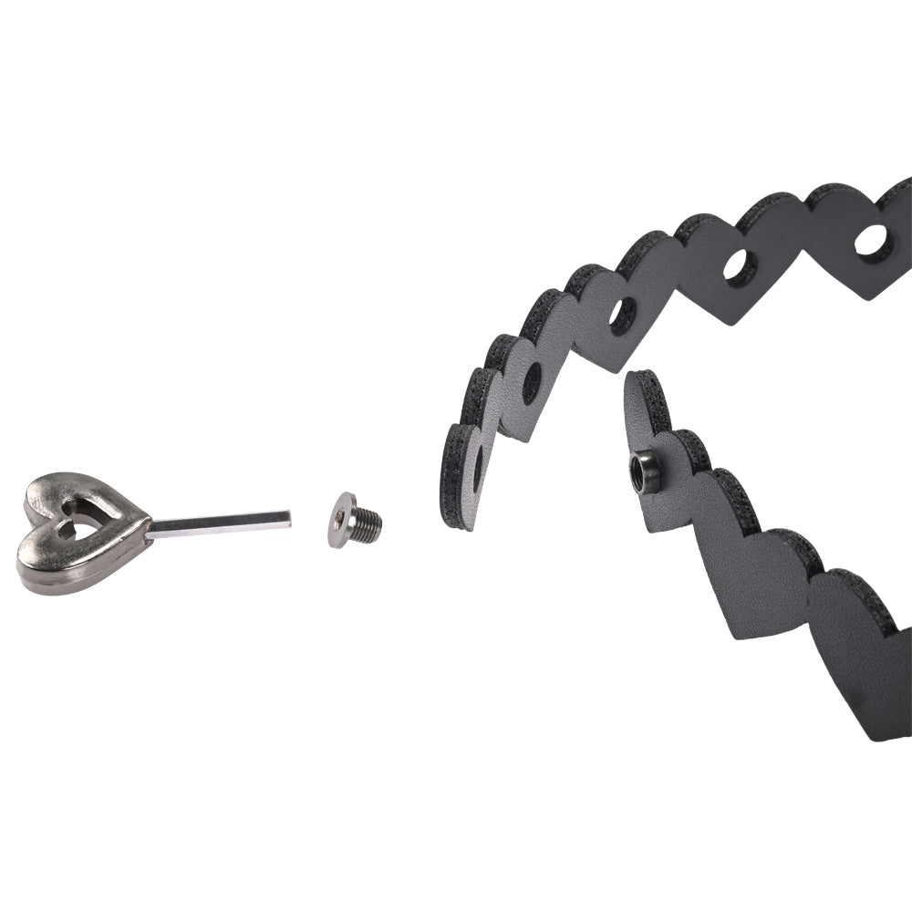 Close-up of a disassembled Sex & Mischief Heart Day Collar in black, featuring a heart-shaped choker collar with hole-punched sections. Includes a separate metal heart clasp with pin and screw attachment on a white background, highlighting its design and functionality.