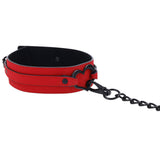 The Sex & Mischief Amor Collar and Leash - Red Restraint features bold red vegan leather with black metal hardware and a heart-shaped loop. It comes with a black chain leash, lined for contrast, making it ideal for those who value style and ethics.