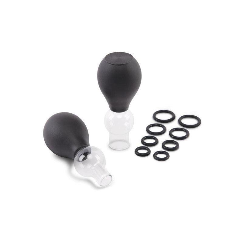 Two Size Up Classic Nipple Pump Sets are displayed, with black silicone chambers resembling bulbs attached to glass tubes. Ten black rubber rings of various sizes are visible to the right, all set against a white background.