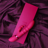 The VIVE Sora, a 24.2 cm pink USB rechargeable Rabbit Vibrator, features a sleek design with a rabbit attachment and metallic ring accent. Made of medical-grade silicone, it rests on its matching pink box against dark fabric, showcasing the VIVE logo that reflects its premium quality.