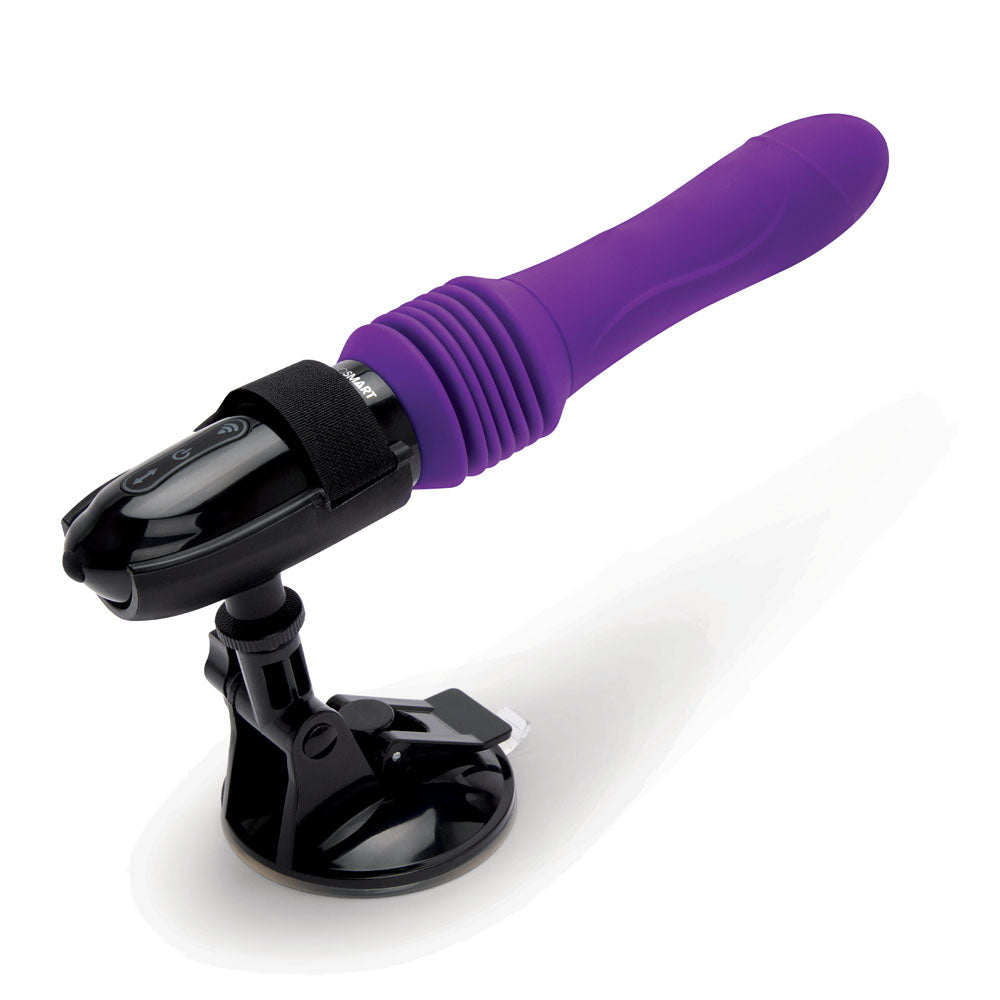 The WhipSmart Thrusting Sex Machine is a purple 23 cm USB rechargeable vibrator with a black adjustable base, equipped with a suction mount. It features ribbed casing, vibration modes, and includes a strap for grip and control interface buttons.