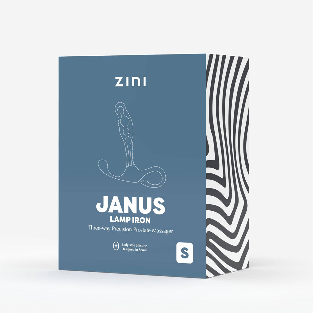 The image shows a box of the Zini Janus Lamp Iron - Small, a red small prostate massager designed for hands-free use. The blue front features an illustration labeling it as a Three-way Precision Prostate Massager, with a black and white wavy pattern on the side.