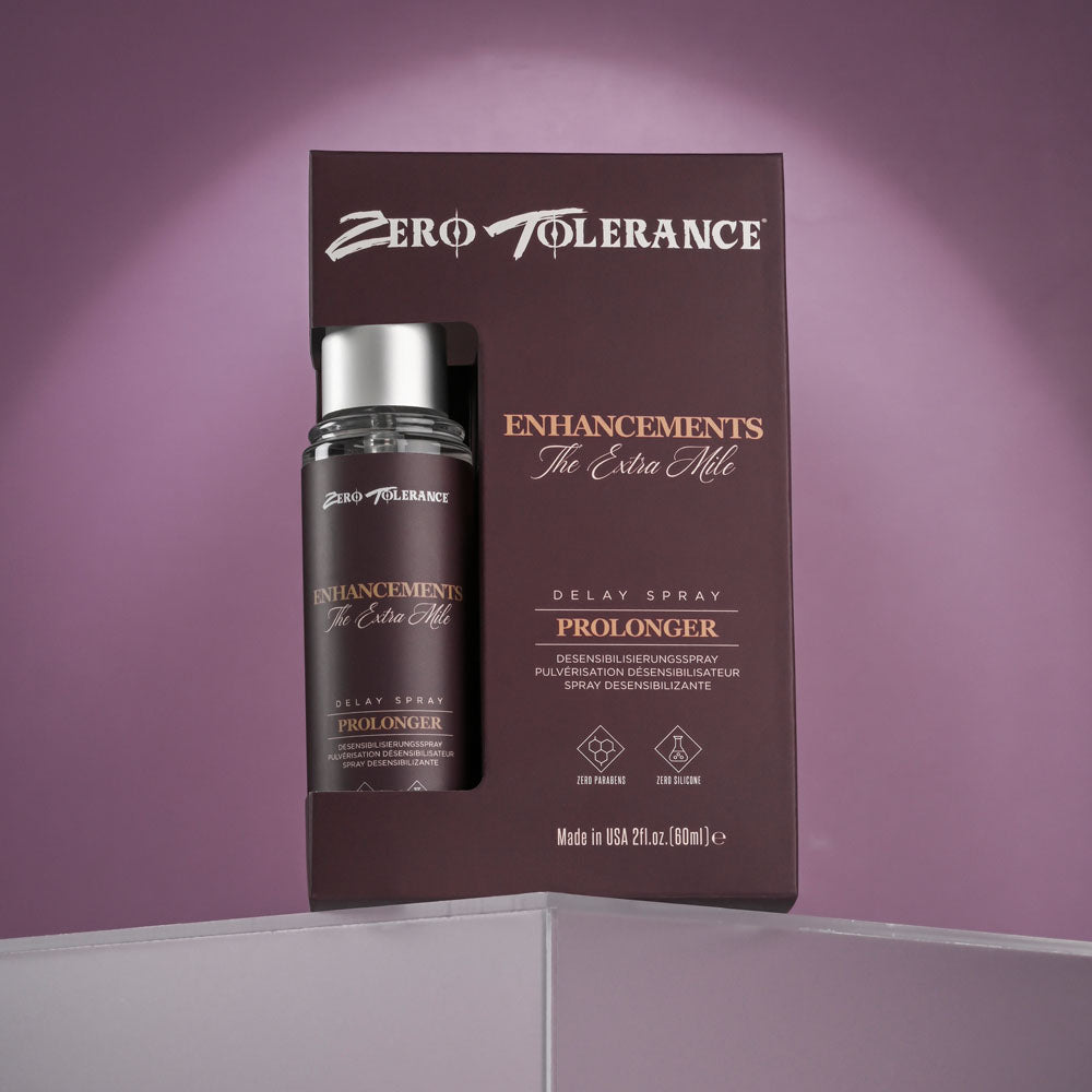 A Zero Tolerance Enhancements - The Extra Mile box features a partially visible, 60 ml Delay Spray for Men bottle for improved performance and increased stamina, showcased against a purple background.