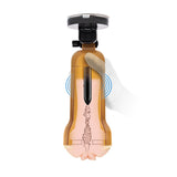 A white-gloved hand holds a brown transparent Zolo Vibrating Personal Trainer, showcasing gear-like features. This hands-free USB rechargeable stroker has a suction mount and blue radiating lines, hinting at vibration or motion for an enhanced experience.