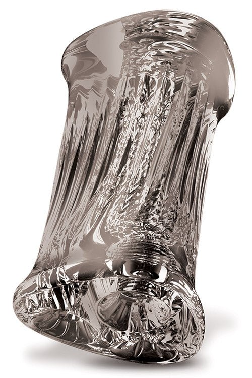 The Adam & Eve Adams 3-Way Stroker features a transparent, cylindrical design with intricate swirls and light-reflective patterns for an easy grip. Its uneven top and bottom edges create an organic flow, while the glossy clear glass adds elegance.