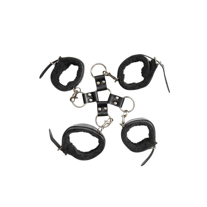 The Adam & Eve Hog Tie - Black Restraints includes four black leather cuffs with fur lining connected by a central metal ring and short straps. Each cuff has a buckle fastening and metal ring, forming an X shape, highlighted against a white background to showcase the BDSM design and texture.